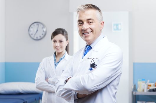 Health care professionals with medical equipment in the background.