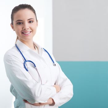 Portrait of a smiling female doctor standing with arms folded 