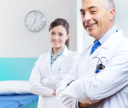 Health care professionals with medical equipment in the background.