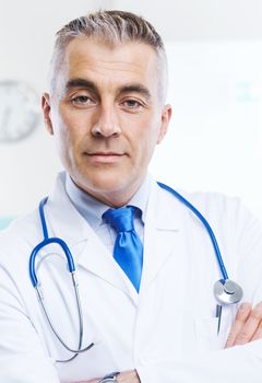 Portrait of an handsome confident doctor with medical equipment.