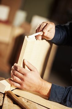 Professional carpenter applying glue on a wooden surface with brush.