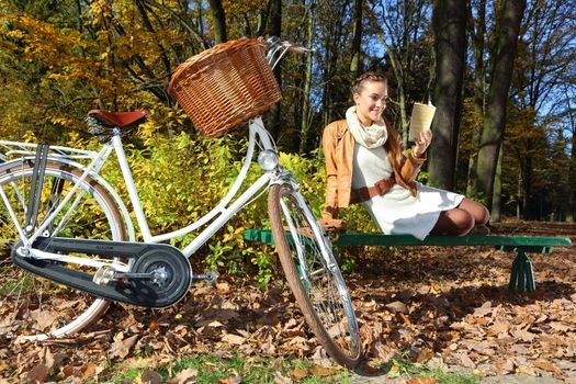 beautiful woman in autumn scenery on a park bench