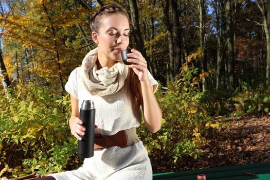 beautiful woman in autumn scenery on a park bench