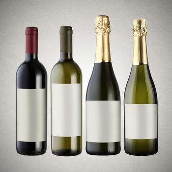 Set of wine bottles on gray background with blank labels.