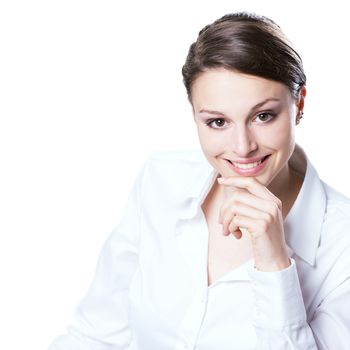 Confident young woman in white shirt with hand on chin smiling at camera.