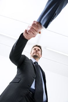 Confident young businessmen shaking hands bottom view.