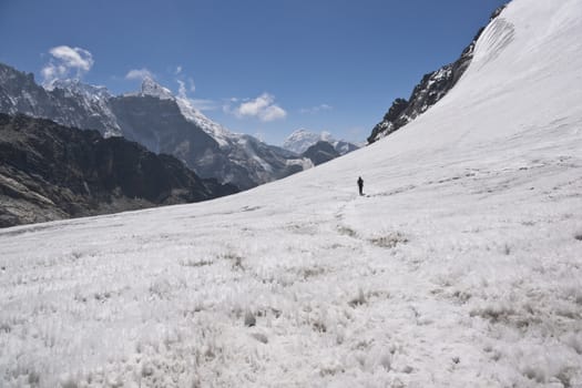 Trekker crossing the pristine glacier in the high altitude pass (Cho La - 5330m) between Everest Base Camp and Gokyo in the Himalaya Mountains of Nepal