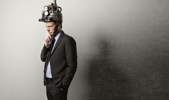 Confident businessman thinking with hand on chin wearing steampunk helmet