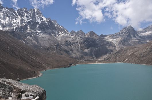 Mountains surrounding the clear blue waters of Gokyo Lake, 4700 meters up in the Himalaya Mountains of Nepal.