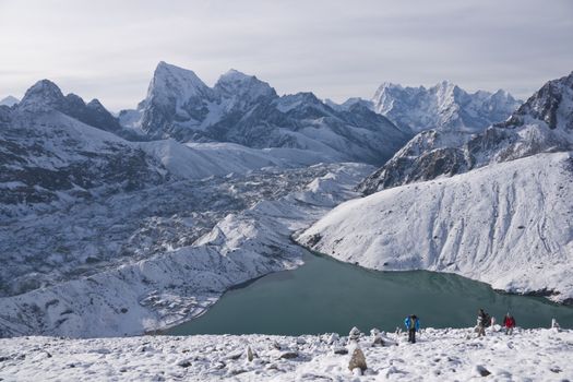 Group of climbing the snow covered mountain side above Gokyo in the Himalaya Mountains of Nepal.