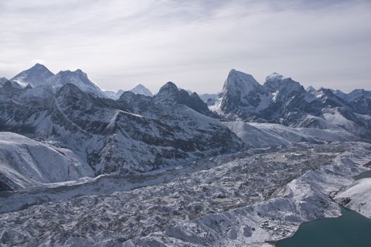 Ngozumpa Glacier dwarfs the snow covered village of Gokyo on the shore of Gokyo lake 4800 meters up in the Himalaya Mountains of Nepal.