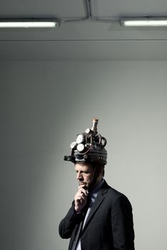 Confident businessman thinking with hand on chin wearing steampunk helmet