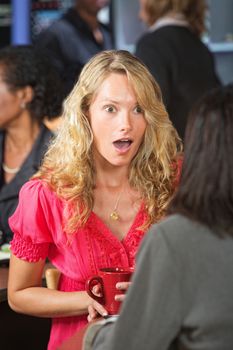 Astonished female talking with friend in restaurant