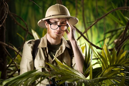 Young explorer in the forest with headache touching his temples.