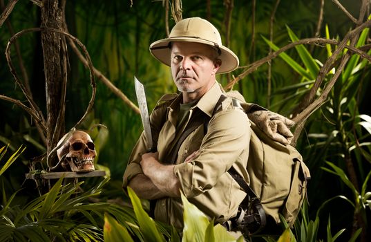 Adventurer with colonial style survival equipment in the jungle with skull.