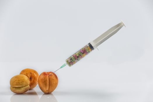 Female menopause and sexual disease metaphor: apricots and syringe with pills meaning cosmetic and health treatment for female ageing