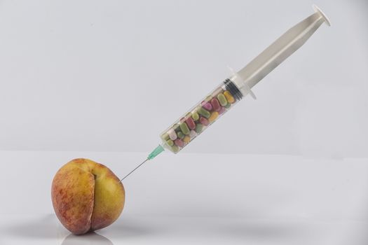 Female menopause and sexual disease metaphor: peach and syringe with meaning cosmetic and health treatment for female ageing