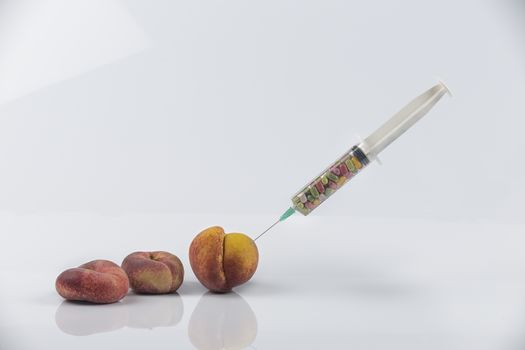 Female menopause and sexual disease metaphor: peaches and syringe with pills meaning cosmetic and health treatment for female ageing