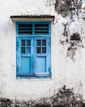 Vivid blue wooden window and grunge wall