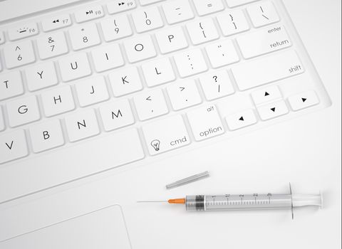 Syringe on the keyboard. View from above