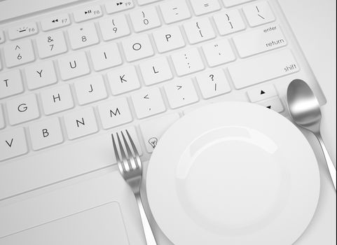 Plate, spoon and fork on the keyboard. View from above