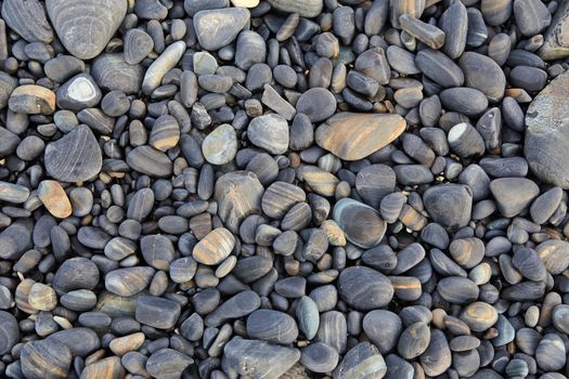 Colorful pebbles touching wave at beautiful rock island, called Koh Hin Ngam, near Lipe island, Thailand