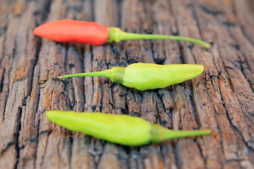 Hot chili pepper on old wooden background