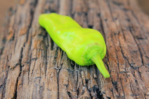 Hot chili pepper on old wooden background