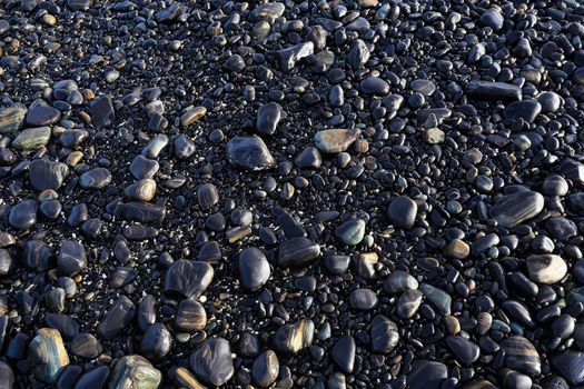 Colorful pebbles touching wave at beautiful rock island, called Koh Hin Ngam, near Lipe island, Thailand