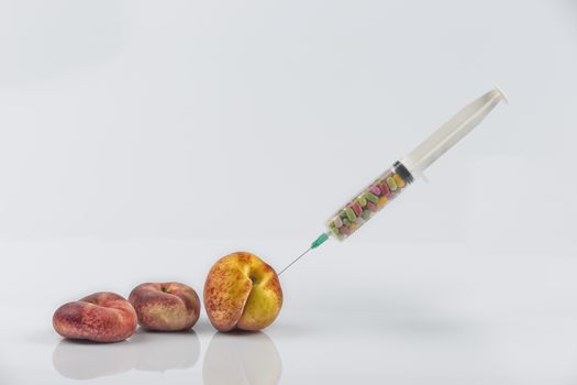 Female menopause and sexual disease metaphor: peaches and syringe with pills meaning cosmetic and health treatment for female ageing