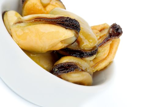 Snack of Smoked Mussels with Olive Oil in White Bowl isolated on white background