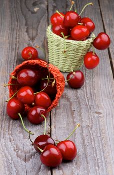 Ripe Sweet Cherries in Two Wicker Baskets closeup on Rustic Wooden background
