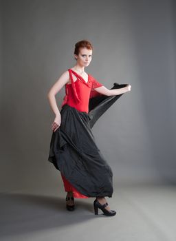 flamenco dancer swinging skirt on a grey background