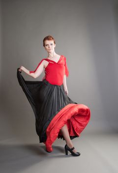 flamenco dancer swinging skirt on a grey background