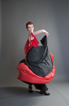 flamenco dancer swinging skirt on a grey background