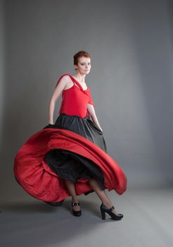 flamenco dancer swinging skirt on a grey background