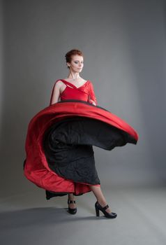 flamenco dancer swinging skirt on a grey background