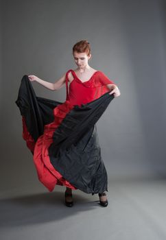 flamenco dancer swinging skirt on a grey background