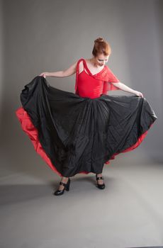 flamenco dancer swinging skirt on a grey background