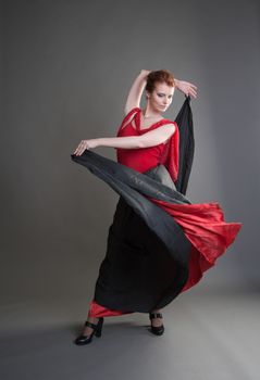 flamenco dancer swinging skirt on a grey background