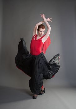 flamenco dancer swinging skirt on a grey background