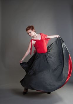 flamenco dancer swinging skirt on a grey background