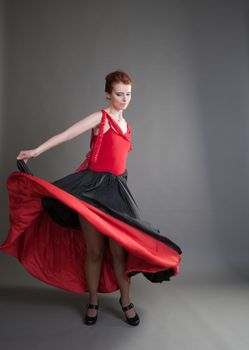 flamenco dancer swinging skirt on a grey background