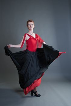 flamenco dancer swinging skirt on a grey background