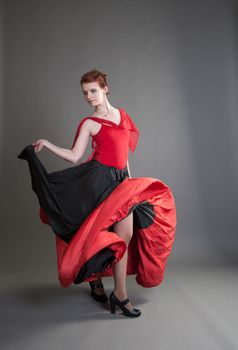 flamenco dancer swinging skirt on a grey background