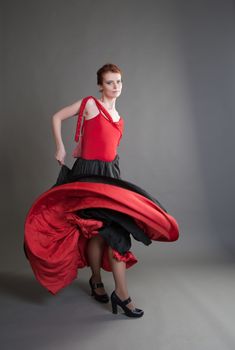 flamenco dancer swinging skirt on a grey background