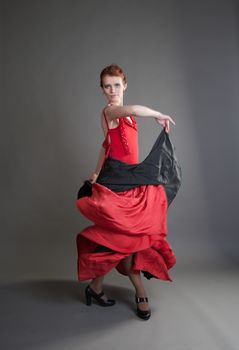 flamenco dancer swinging skirt on a grey background