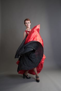 flamenco dancer swinging skirt on a grey background