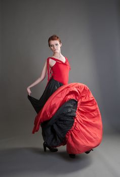 flamenco dancer swinging skirt on a grey background