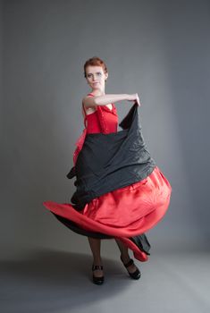flamenco dancer swinging skirt on a grey background